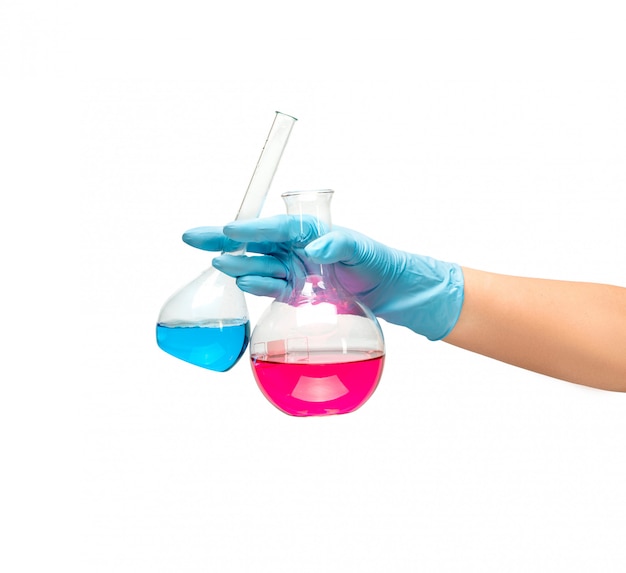 Female hands in a blue rubber glove holds a flask of red blue medicine on white background isolate.