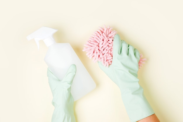 female hands cleaning on pale yellow background cleaning or housekeeping