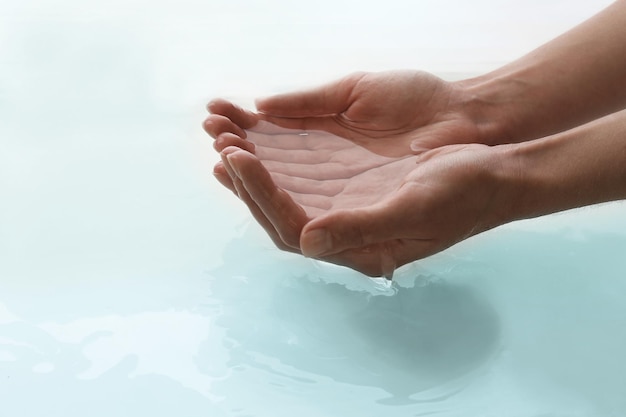 Photo female hands over clear water background