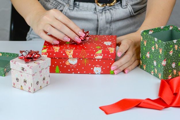 женские руки крупным планом упаковка рождественских подарков ручной работы рождественский декор на столе