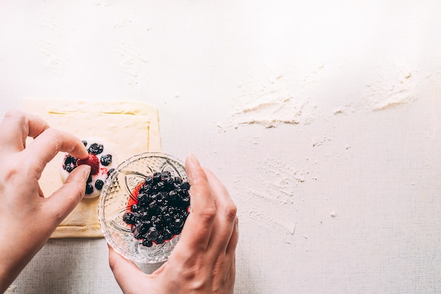 Le mani femminili cucinano la torta della pasta fatta in casa