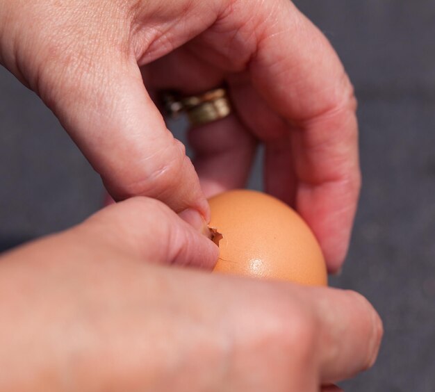 Female hands cracking open egg