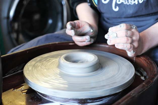 Female hands crafting a pottery cup on a potter wheel Handmade and crafting concept