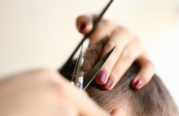 female hands cutting brown hair with scissors
