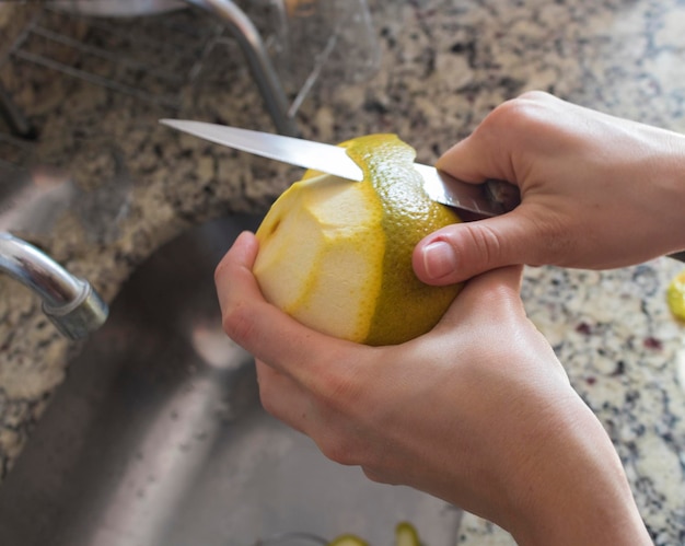 Female hands cutting orange in kitchen