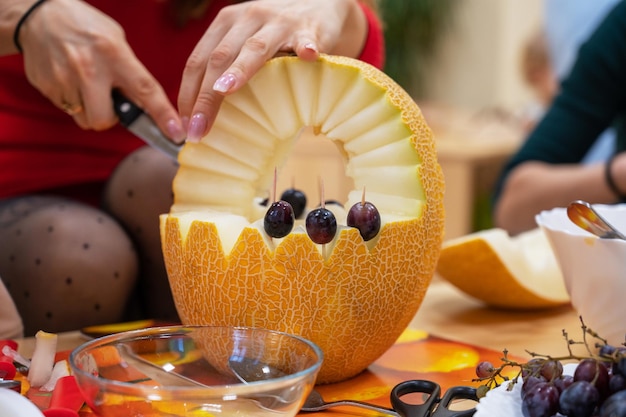 Mani femminili che tagliano la zucca ad halloween