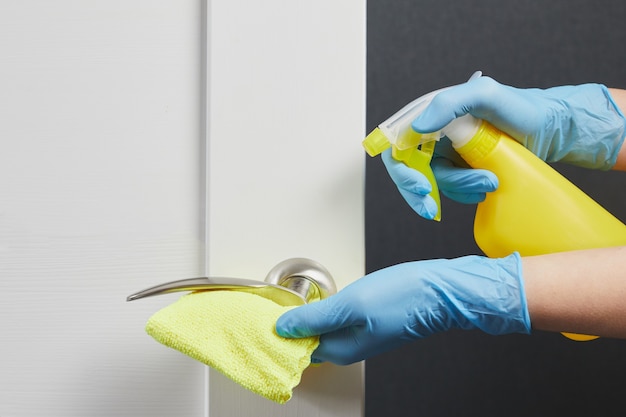 Female hands disinfect clean and wash of door handles Prevention of coronavirus during COVID19