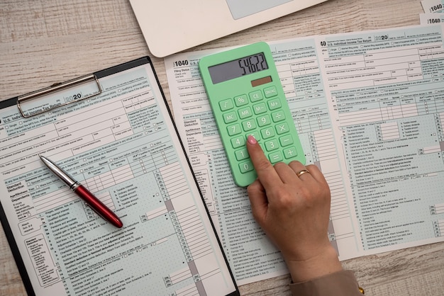 Female hands filling individual income tax return 1040, paperworks concept