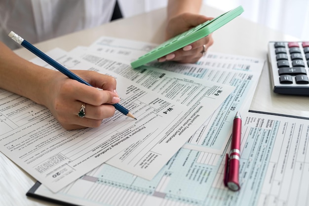 Female hands filling up 1040 individual tax form close up