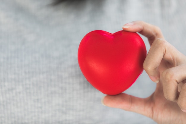 Female hands giving red heart