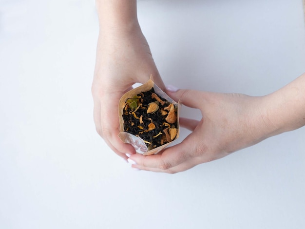 In female hands a glass jar with dry herbal tea anonymized photo