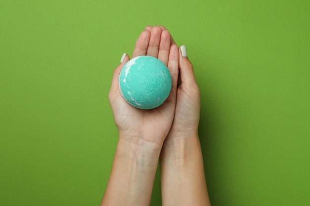 Female hands hold bath ball on green background