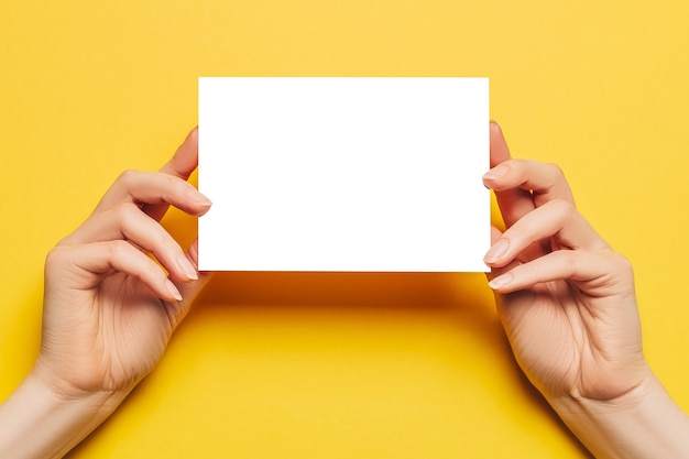 Female hands hold a blank sheet of paper