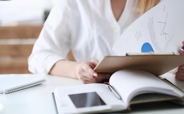 Female hands hold clipboard pad with financial