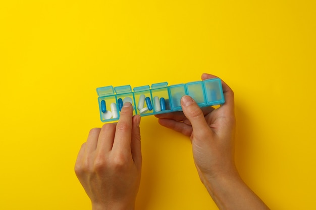 Female hands hold container with pills