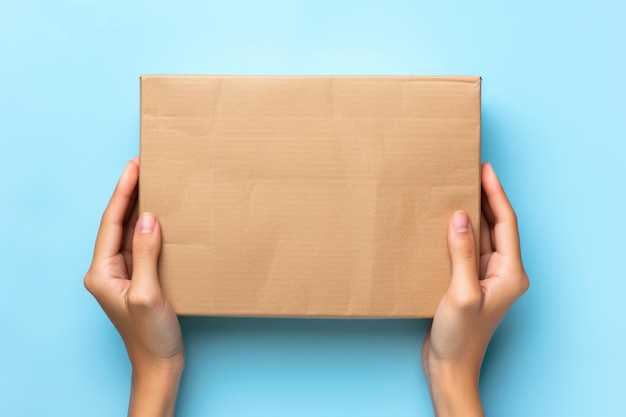 Female hands hold eco friendly package box on blue background