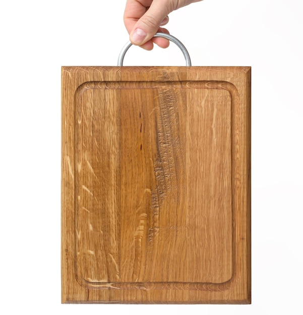 Photo female hands hold empty rectangular brown wooden chopping board on white background