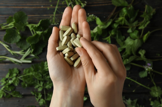 Female hands hold herbal medicine pills, top view
