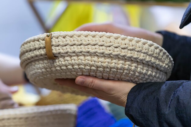 Женские руки держат вязаную или плетеную корзину.