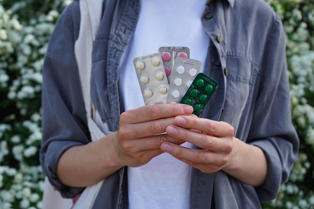 Женские руки держат таблетки от здоровья на открытом воздухе и медицинской концепции