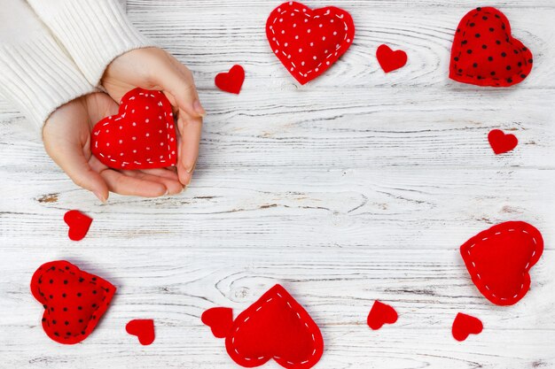 Female hands hold red heart.