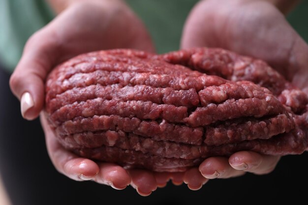 Female hands hold red minced meat closeup