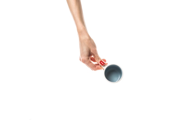 Female hands hold a white ceramic cup on white background Female hands with fresh red manicure Isolated on white background