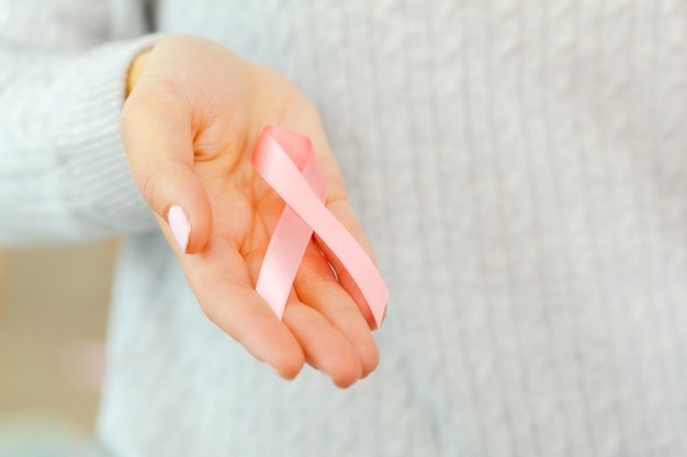 Female hands holding AIDS awareness ribbon