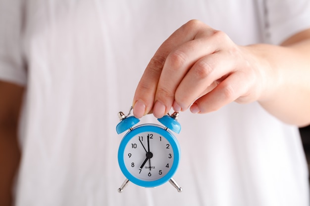 Female hands holding alarm clock