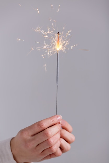 Foto mani femminili che tengono la luce del bengala.