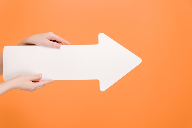 Female hands holding big white paper arrow