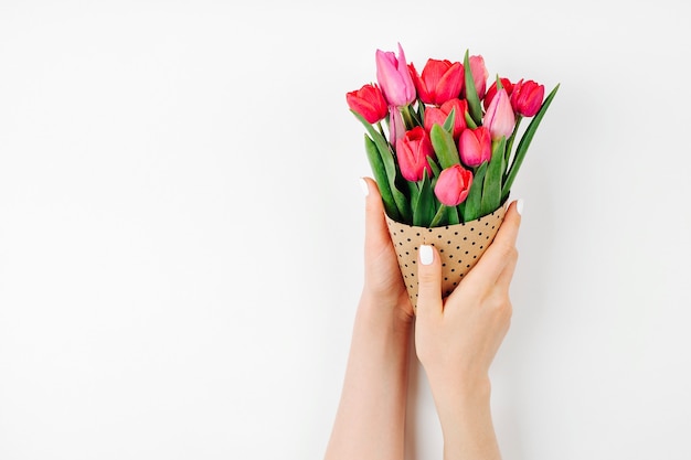 Female hands holding a bouquet of tulips wrapped in paper