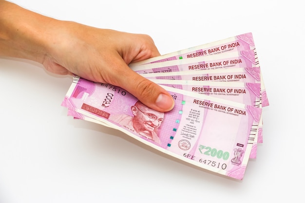 Female hands holding brand new 2000 indian rupees banknotes.