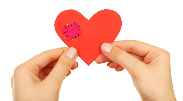 Female hands holding broken heart with patch isolated on white