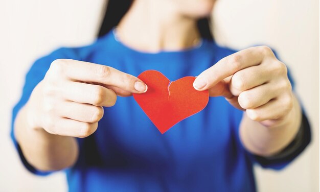 Foto mani femminili che tengono un cuore spezzato