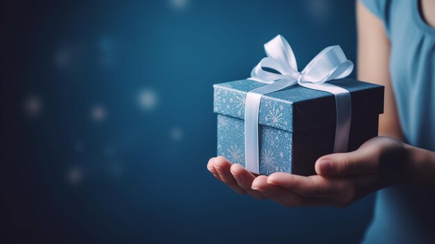 Photo female hands holding christmas gift box on blue background