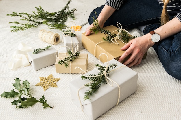 Female hands holding a Christmas present wrapped in natural vintage paper