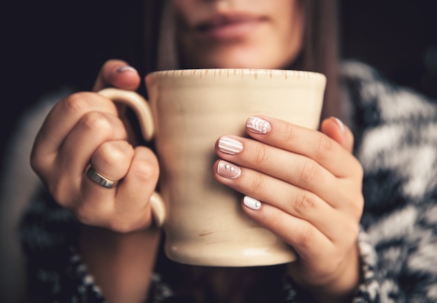 Female hands holding a cup of coffee