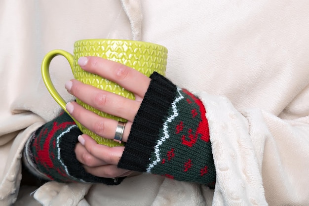 Female hands holding a cup with hot beverage