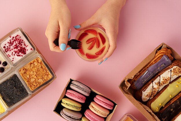 Female hands holding dessert in hands among fresh confectionary, close up