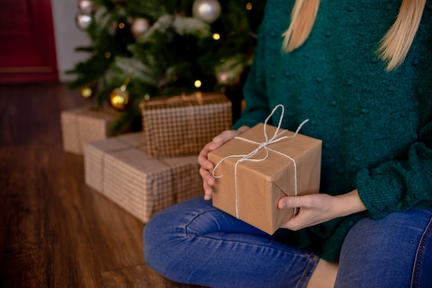 Female hands holding gift. Present Wrapped with craft paper. Top horizontal view holiday concept copyspace.