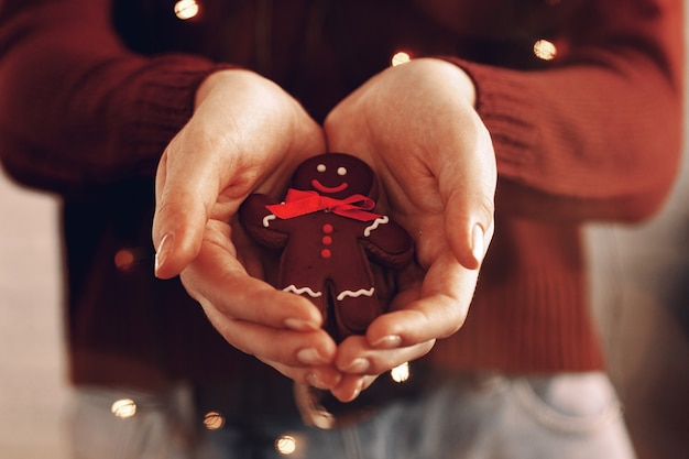 Female hands holding gingerbread man close up, christmas concept