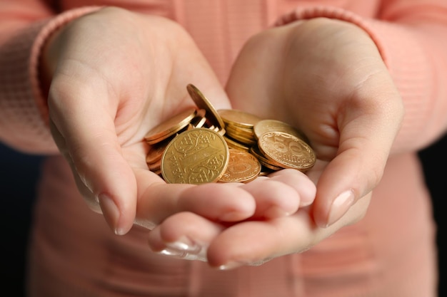 Female hands holding a handful of Ukrainian coins close up