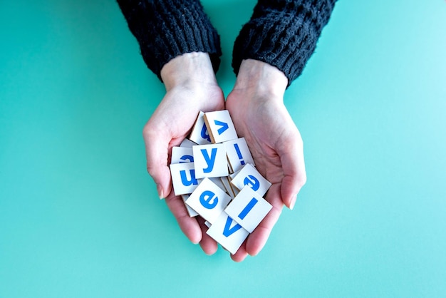 Female hands holding letters on green background happy children's day