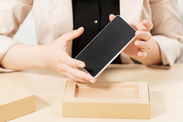 Photo female hands holding new smartphone