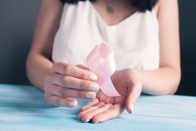 Female hands holding a pink ribbon