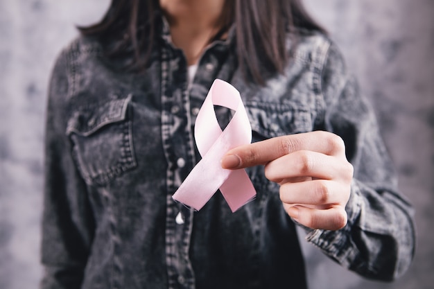 Female hands holding a pink ribbon