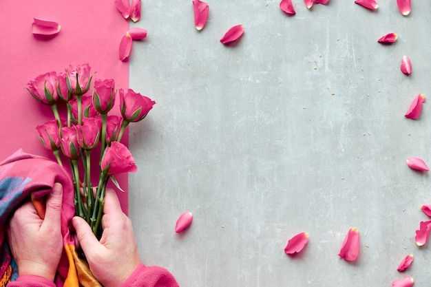 female hands holding pink roses and vibrant trendy scarf