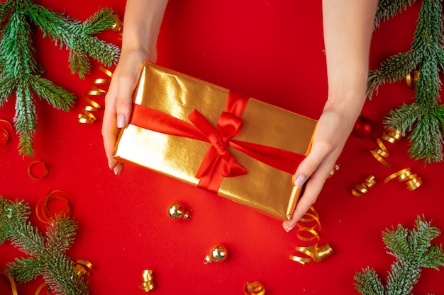 Female hands holding present on a red 