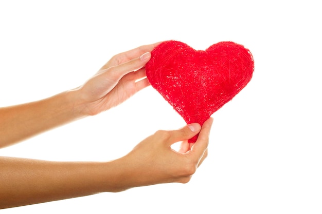 Foto mani femminili che tengono un cuore rosso